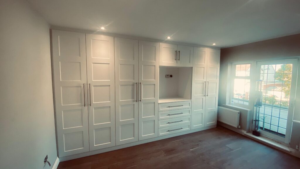 Elegant bespoke wardrobes in a modern bedroom showing high quality built-in storage and custom shelving.