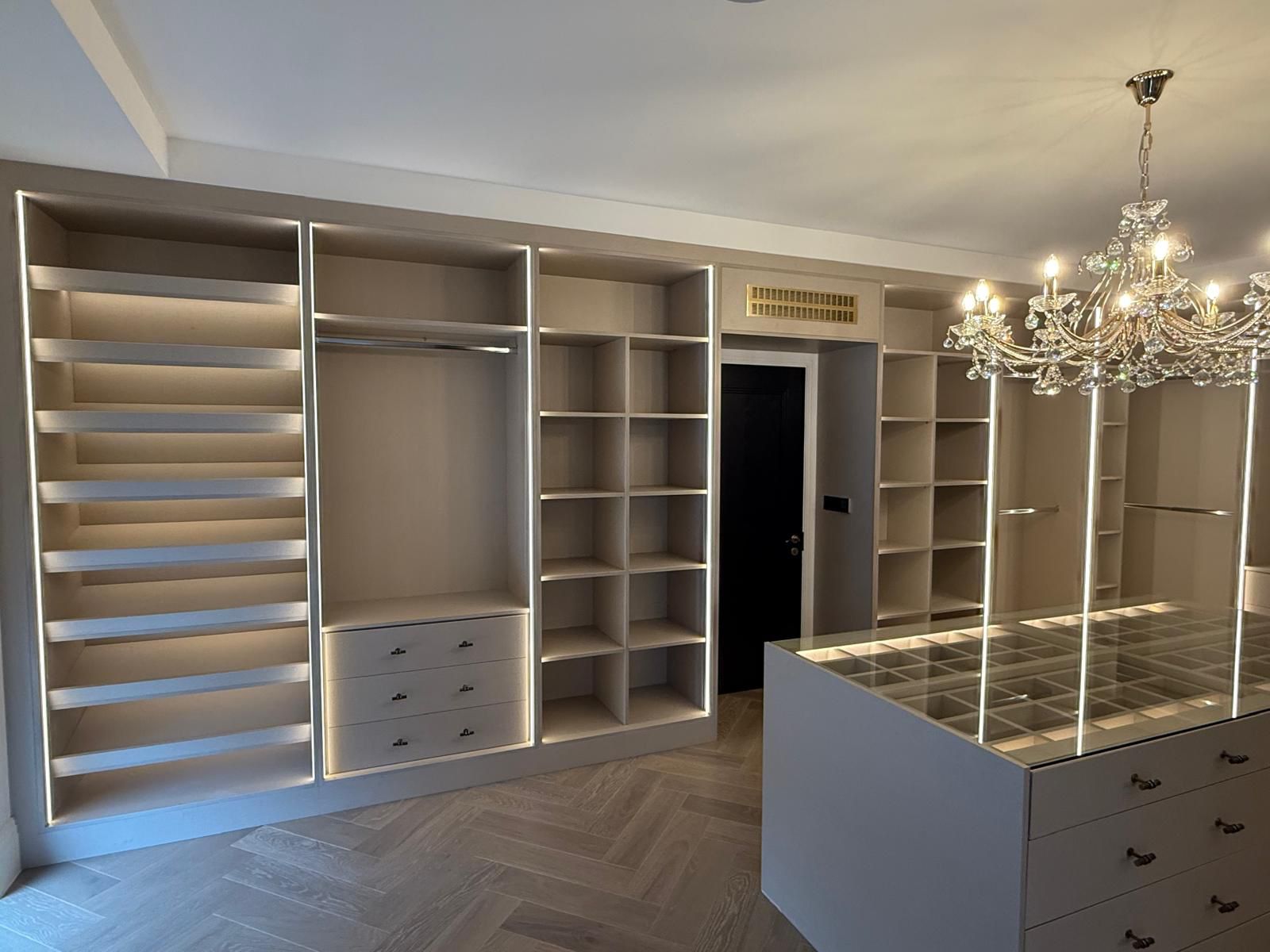 Modern walk-in wardrobes in a small UK room showing high quality custom storage with shelves and hanging rails for a tidy dressing area.